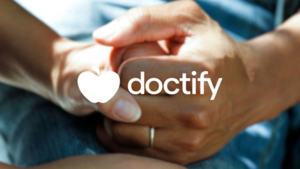 Doctify company logo overlaid on a photo of a person's hand being held by another to symbolise the patient care and connection created by the Doctify platform, which helps patients connect wit private healthcare providers.