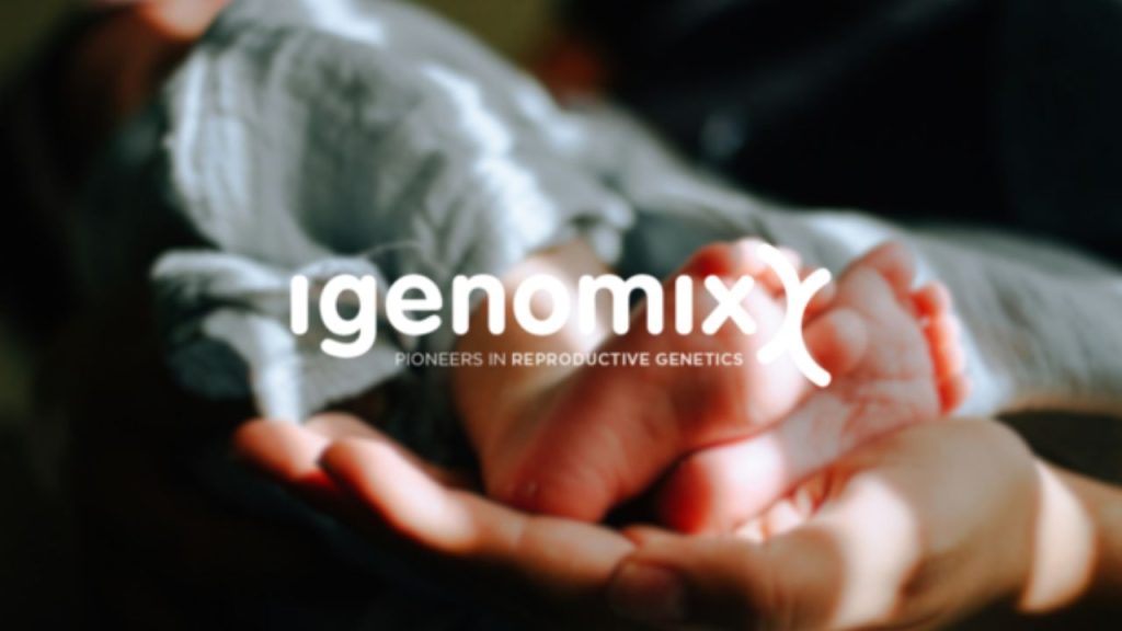 Igenomix company logo overlaid on a photo of a close up of an adult hand cradling the feet of a baby.