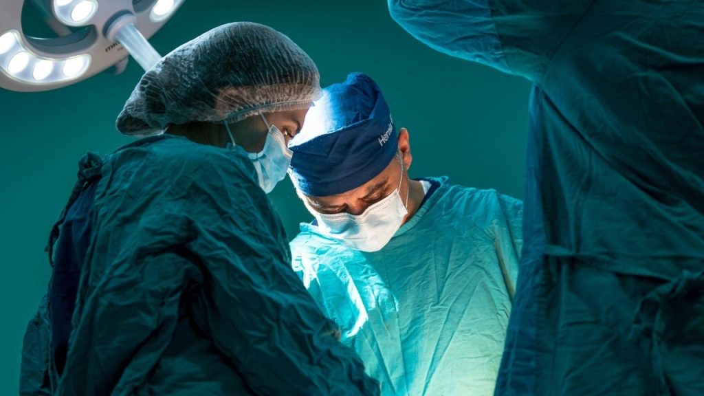 A photo of surgeons in an operating theatre, depicting the environment of organ transplantation, which OrganOx technology improves outcomes for.