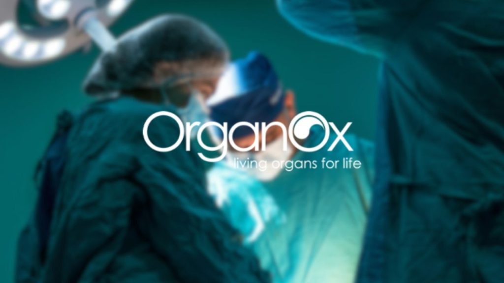 OrganOx company logo overlaid on a photo of surgeons in an operating theatre, depicting the environment of organ transplantation, which OrganOx technology improves outcomes for.