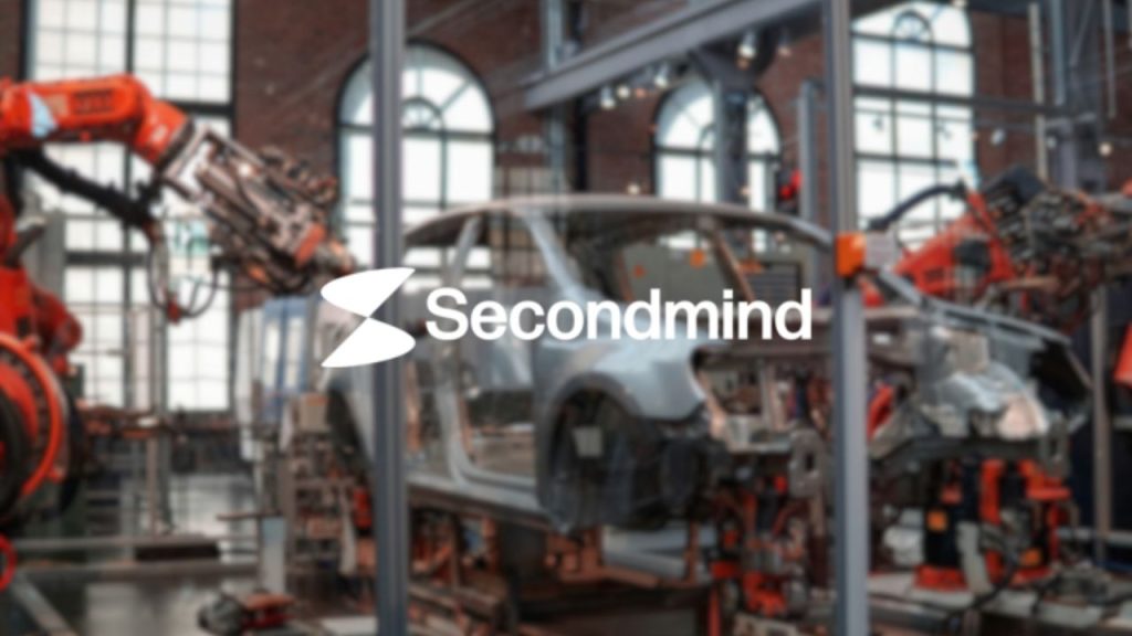 Secondmind company logo overlaid on an image of a robotic arm working on constructing a car as part of an automotive construction line in a factory. The image is representative of the AI decision making platform which Secondmind has developed to to help car makers design betters cars, faster.