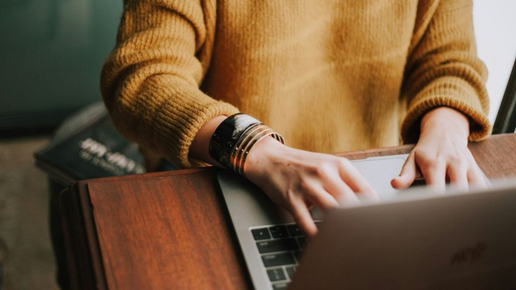 A person sat at a desk using a laptop, representative of the AI-powered automation software Sprout.ai has developed to help insurers with claims.