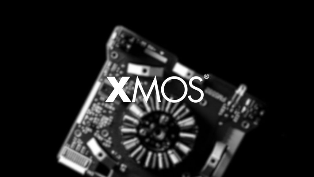 XMOS company logo overlaid on a a close up image of a circuit board used to represent the fabless semiconductor designs created by XMOS.