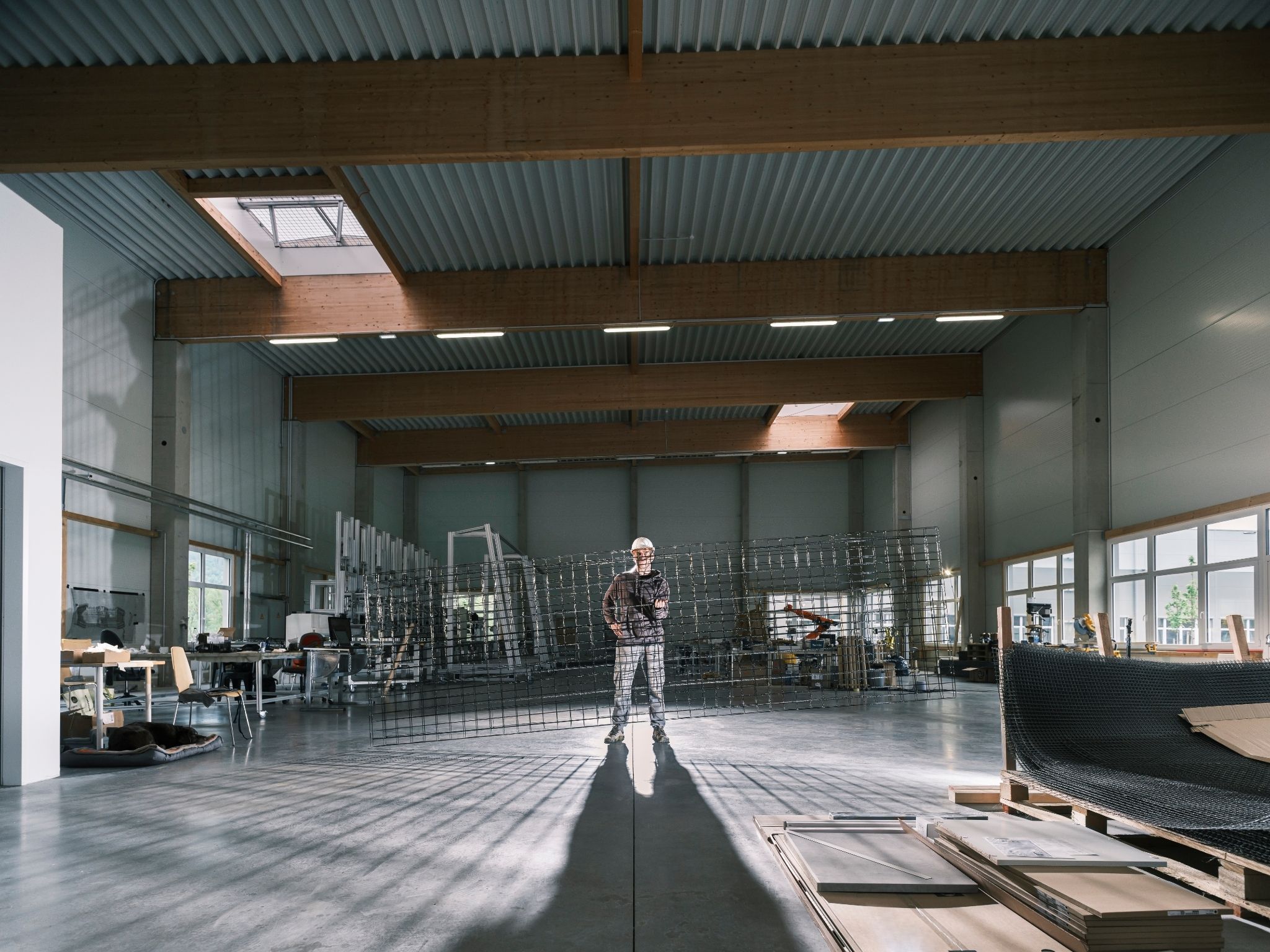 Engineer holds 3D basalt fibre reinforcement grid inside Fiber Elements factory workshop.