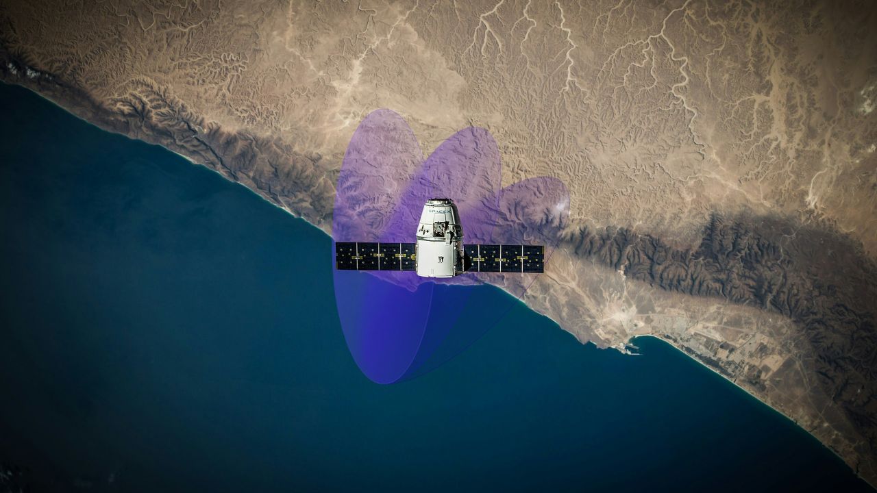 Satellite in low-Earth orbit casting blue-purple coverage cones over a desert coastline, illustrating the space tech stack.