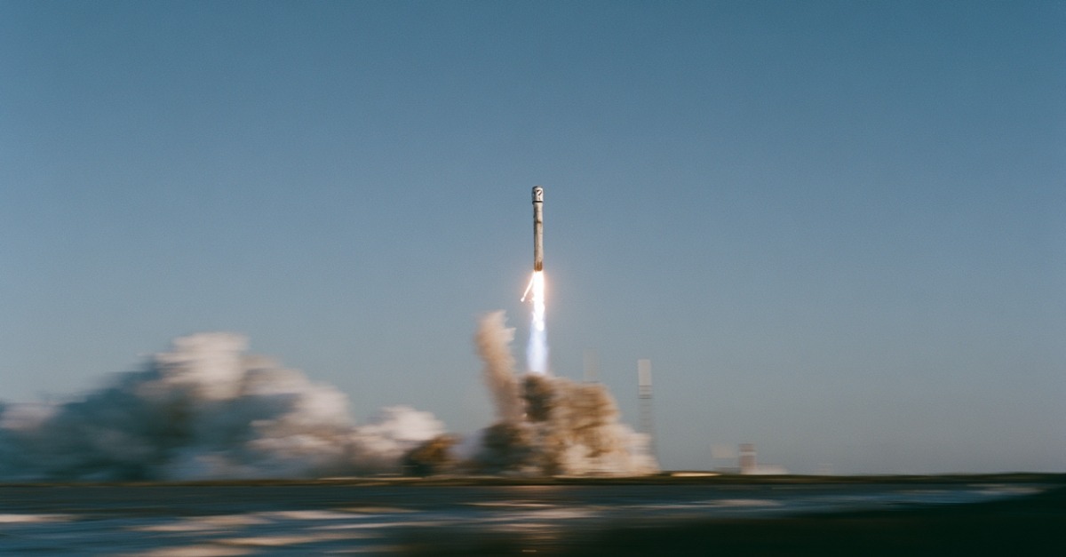 An AI-generated image of a rocket launching at Cape Canaveral. The rocket has a question mark logo on its side and the image has motion blur.